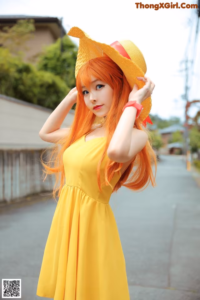 A woman in a yellow dress and a straw hat.