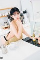 A woman sitting at a kitchen counter with a cup of coffee.