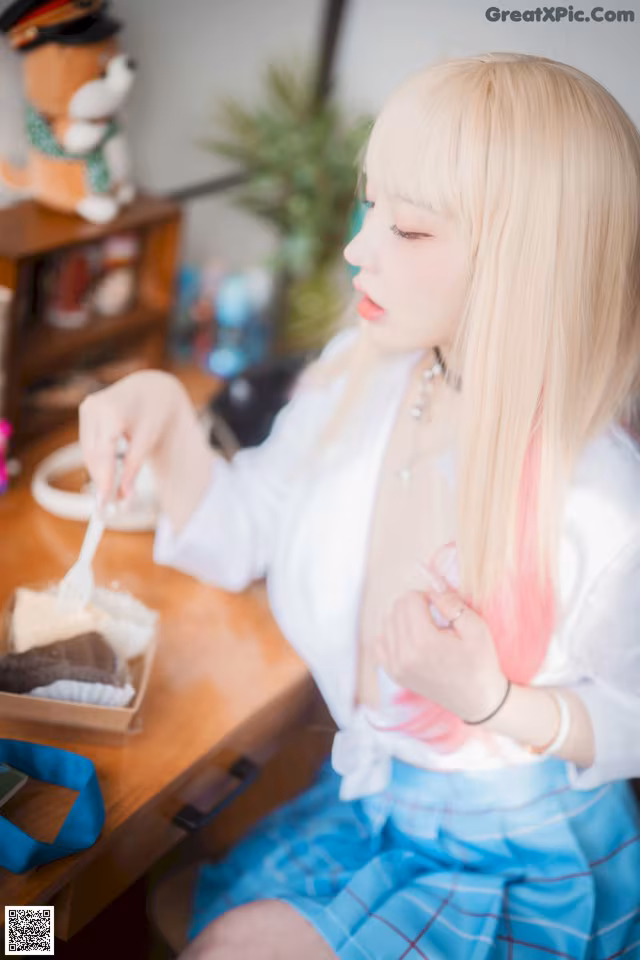 A woman sitting at a table eating a piece of cake.