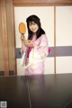 A woman in a pink kimono holding a mirror.