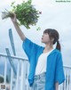 A woman holding a bunch of flowers in her hand.