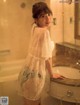 A woman standing in front of a bathtub in a bathroom.