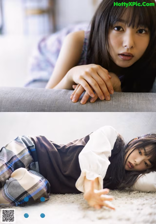 A woman laying on the floor next to a couch.